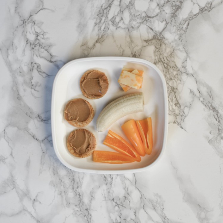 baby led weaning dinner idea: peanut butter crackers, orange mini bell peppers, half a banana and cheese