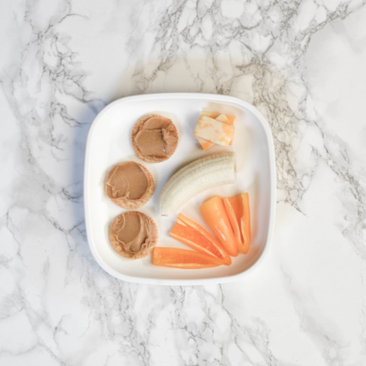 baby led weaning dinner idea: peanut butter crackers, orange mini bell peppers, half a banana and cheese